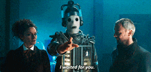 a man and woman are standing next to a robot who says i waited for you .