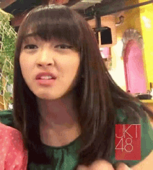 a woman wearing a green shirt with jkt 48 written on the front