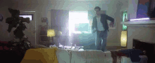 a man is standing in a living room in front of a window