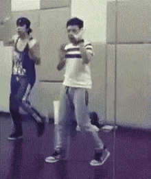 two people are dancing in front of a mirror in a room .