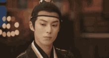 a close up of a man wearing a headband with a flower on it