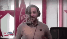 a man wearing headphones is talking into a microphone in a radio station .