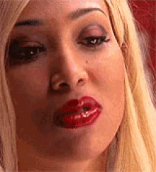 a woman with red lips is making a funny face .