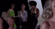 a woman in a green dress is standing in front of a group of people .