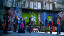a group of people standing in front of a building with a sign that says ' a & r ' on it