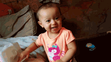 a baby in a pink shirt with a cat on it