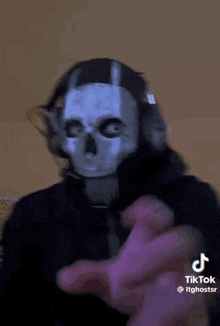 a man wearing a skull mask and headphones is dancing .