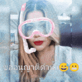a woman wearing a pink goggles and a snorkel has a smiley face on her face