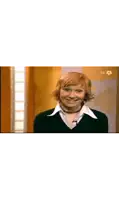 a woman with a wig on her head is smiling on a tv show