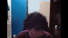a person 's head is visible in a dark room with a blue wall