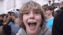 a boy with a surprised look on his face stands in front of a crowd