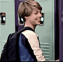 a young boy with a backpack is standing in front of a purple door .