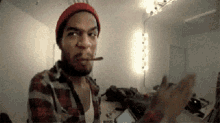 a man wearing a red hat and plaid shirt is smoking a cigar