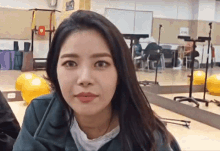 a woman in a gym looking at the camera with a sign on the wall that says ' a ' on it