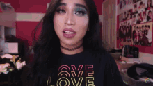 a woman is wearing a black shirt that says love