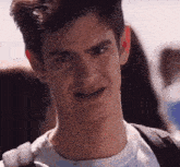 a close up of a man 's face with a backpack behind him