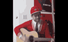 a man in a red hat playing a guitar