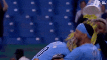 a baseball player is being helped off the field by a man .
