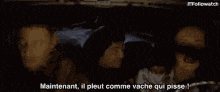 a group of people sitting in a car with the words " maintenant il pleut comme vache qui pisse " written on the bottom