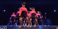 a group of young girls are dancing on a stage in front of a sign that says cd .