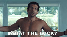 a shirtless man is standing in front of a window and says what the fuck