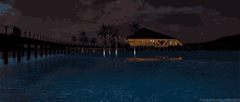 a beach scene at night with a dock and palm trees in the background