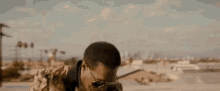 a man is giving the middle finger while standing on top of a roof .