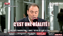 a man speaking into a microphone with the words c est une realite