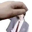 a hand is holding a picture of a man in a suit and tie on a white background .