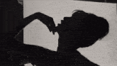 a silhouette of a woman laying on her back with her legs up