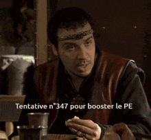 a man sitting at a table with a headband on his head and the words tentative n 347 pour booster le pe written below him