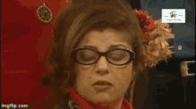 a woman wearing glasses and a flower in her hair has a watermark that says share media