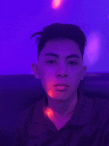 a young man is taking a selfie in front of a purple background