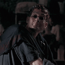 a man wearing sunglasses and a robe is holding a cup in his hands .