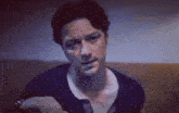 a man is sitting on a couch and looking at the camera .