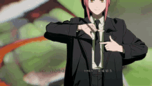 a person in a suit and tie is pointing at their chest