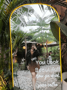 a woman taking a picture of herself in front of a large mirror that says hey you look beautiful now go drink some coffee
