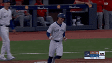 a baseball player wearing a blue jays jersey runs to first base