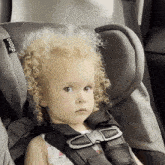a little girl is sitting in a car seat that says diono on the side