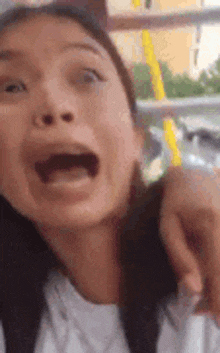 a close up of a woman making a funny face with her mouth open
