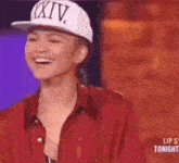 a woman wearing a white hat with the word xiv on it is smiling .