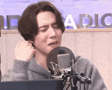 a man is singing into a microphone in front of the word radio