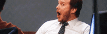 a man in a white shirt and tie looks surprised