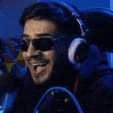 a man wearing headphones and sunglasses is laughing in front of a wheel of fortune .