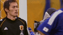 a soccer player wearing a black adidas jersey