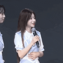 a girl is holding a microphone in her hand while standing next to another girl .
