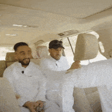 a group of men sitting in the back of a car