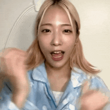 a young woman with blonde hair is wearing a blue pajama top