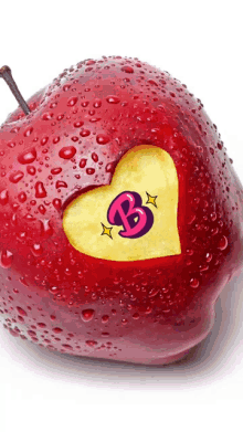 a red apple with a heart cut out of it with the letter b on it