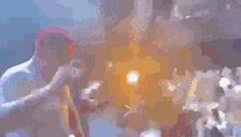 a blurry picture of a man holding a microphone in front of a crowd